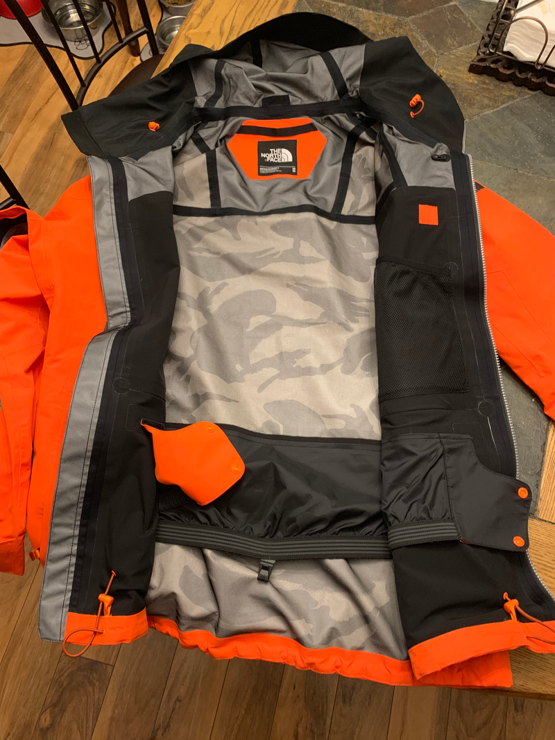 Inside has a gray camo pattern. Not much else going on. You can see a headphone pass through from the outer left chest pocket, a goggle pocket, all of the seam taping. The powder skirt has a clip for hooking onto compatible pants. My pants are also from The North Face but they don’t have a loop for the hook.